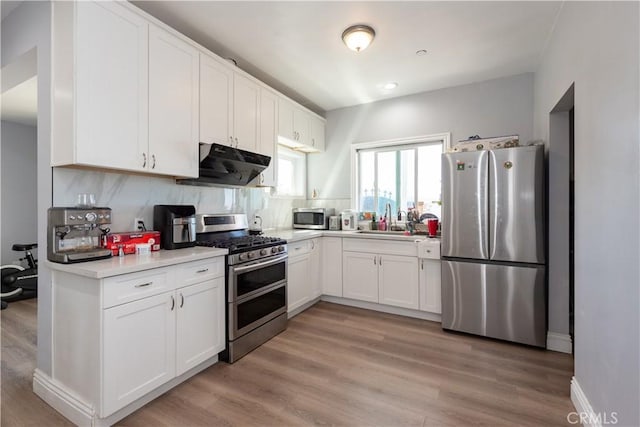 2302 Delfs Ln, Rowland Heights, CA 91748 - kitchen with appliances with stainless steel finishes, under cabinet range hood, a sink, white cabinetry, and light countertops