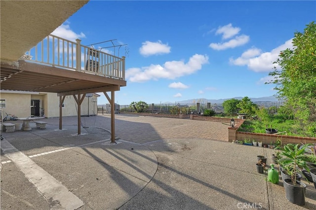 view of patio featuring a mountain view and fence