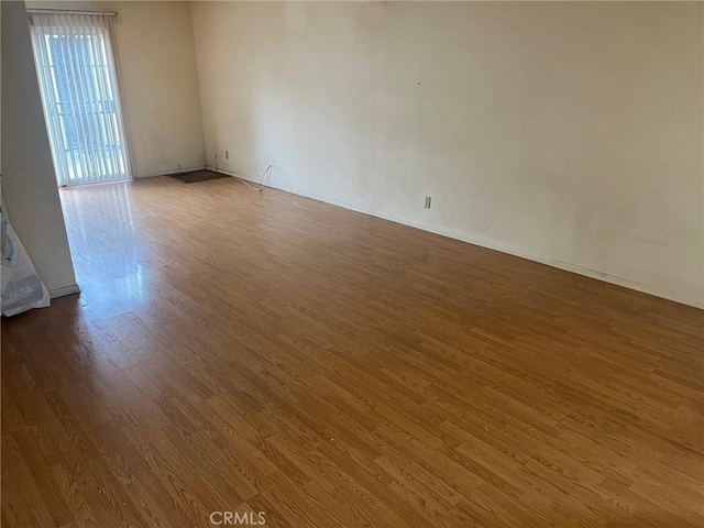 empty room featuring baseboards and wood finished floors