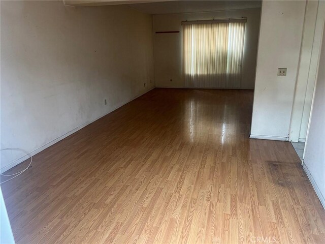 unfurnished room featuring wood finished floors and baseboards