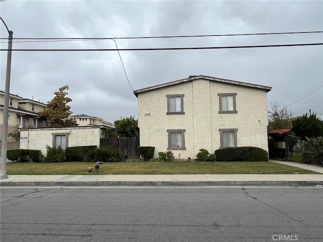 view of home's exterior with a yard, stucco siding, and fence