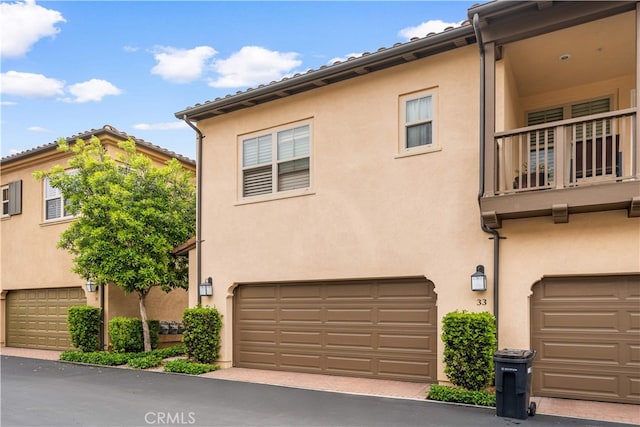 33 Jonquil, Irvine, CA 92618 - view of front of property with a garage, stucco siding, and a balcony