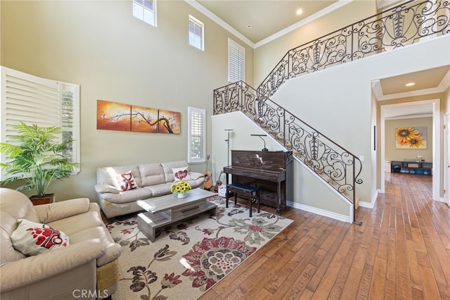 16673 Carob Ave, Chino Hills, CA 91709 - living area featuring hardwood / wood-style floors, a towering ceiling, crown molding, stairs, and baseboards