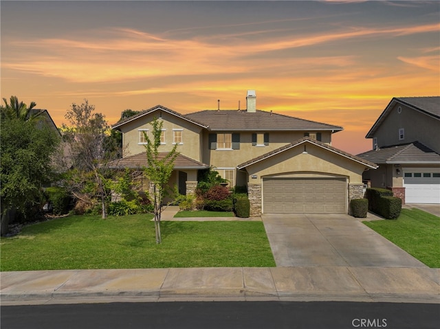 16673 Carob Ave, Chino Hills, CA 91709 - traditional-style house featuring a garage, concrete driveway, stucco siding, a front lawn, and a chimney