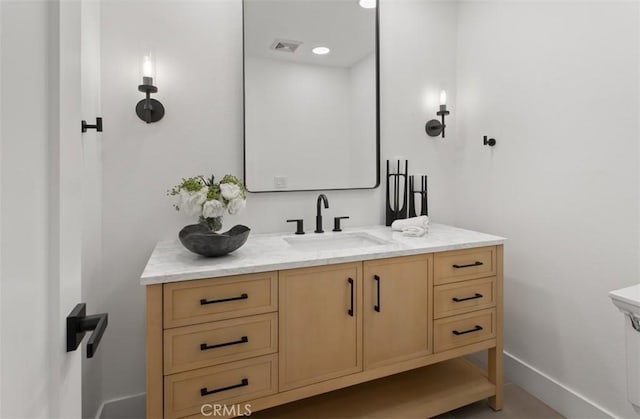 bathroom featuring baseboards, vanity, and visible vents