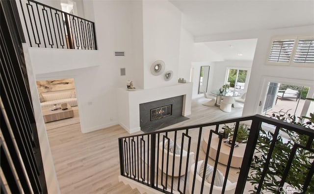 interior space with baseboards, high vaulted ceiling, and wood finished floors
