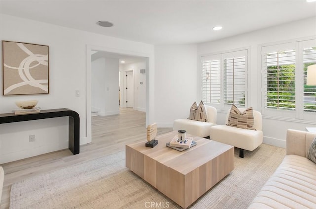 living room with light wood finished floors, baseboards, and recessed lighting