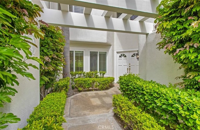view of exterior entry with stucco siding
