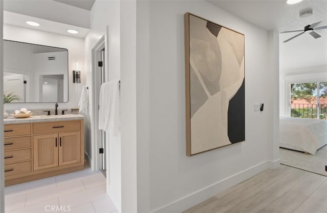 ensuite bathroom with baseboards, ensuite bath, vanity, and recessed lighting