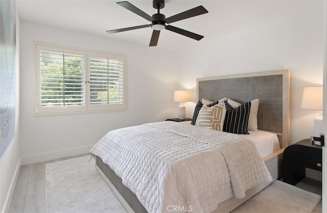 bedroom with baseboards, a ceiling fan, and wood finished floors