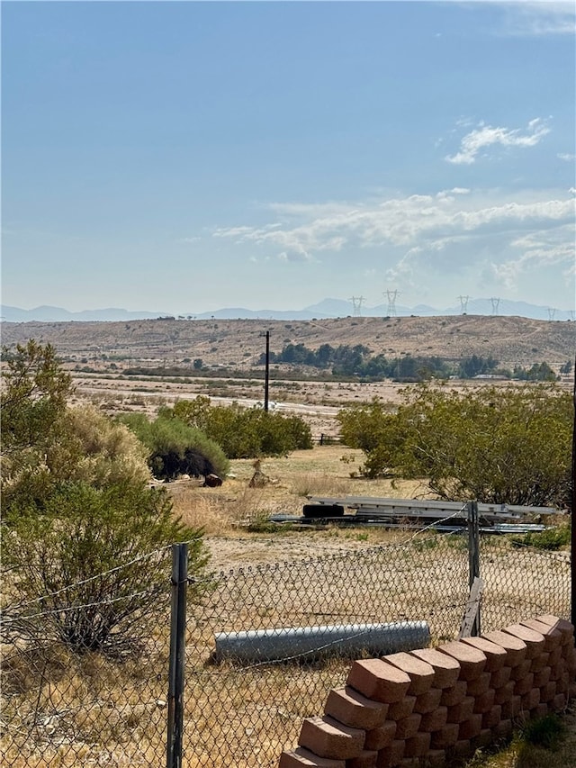 view of yard featuring a mountain view and fence