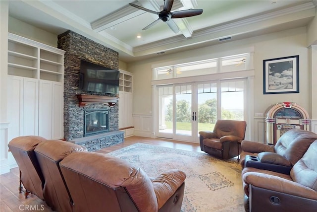 2483 Manhattan Bar Rd, Auburn, CA 95603 - living area with crown molding, a decorative wall, wood finished floors, a stone fireplace, and beamed ceiling