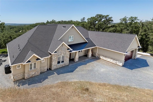 2483 Manhattan Bar Rd, Auburn, CA 95603 - view of front of house with stone siding, a garage, driveway, and cooling unit