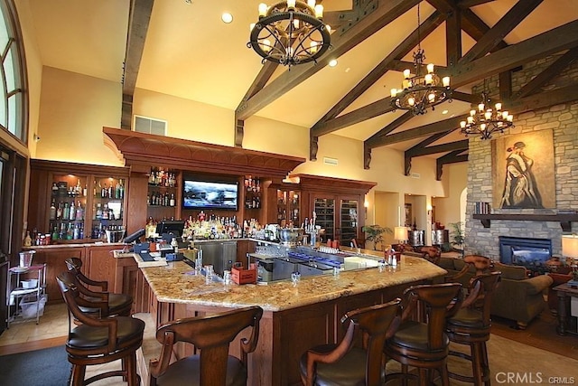 bar with bar area, a chandelier, beamed ceiling, and high vaulted ceiling