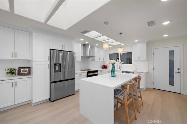 663 Via Los Altos Unit Q, Laguna Woods, CA 92637 - kitchen with stainless steel fridge, wall chimney exhaust hood, range with electric cooktop, white cabinets, and recessed lighting