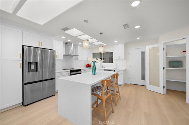 663 Via Los Altos Unit Q, Laguna Woods, CA 92637 - kitchen with stainless steel fridge, wall chimney exhaust hood, electric range, white cabinets, and recessed lighting