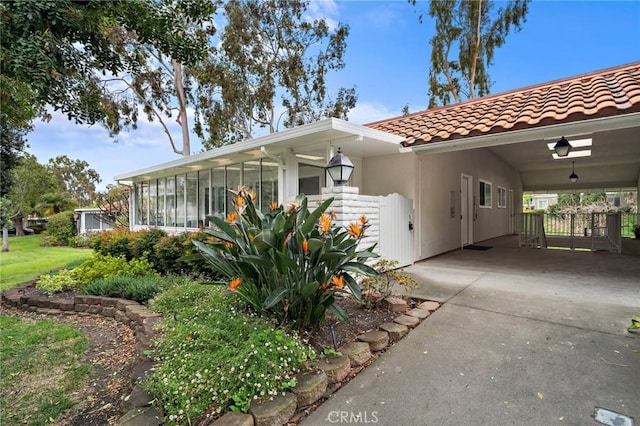 663 Via Los Altos Unit Q, Laguna Woods, CA 92637 - view of front of home featuring a tiled roof, an attached carport, driveway, a sunroom, and stucco siding