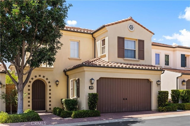 63 Birmingham, Irvine, CA 92620 - mediterranean / spanish-style house with a garage, a tiled roof, stucco siding, and decorative driveway