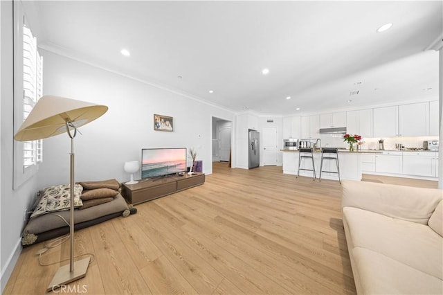 63 Birmingham, Irvine, CA 92620 - living room with crown molding, light wood finished floors, recessed lighting, and baseboards