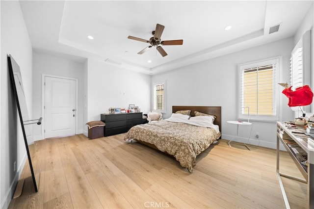 63 Birmingham, Irvine, CA 92620 - bedroom featuring a tray ceiling, light wood-style floors, multiple windows, and recessed lighting