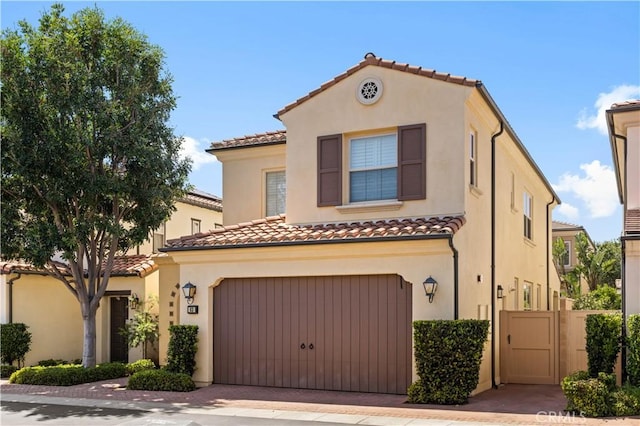 63 Birmingham, Irvine, CA 92620 - mediterranean / spanish-style house with a tiled roof, an attached garage, stucco siding, and driveway