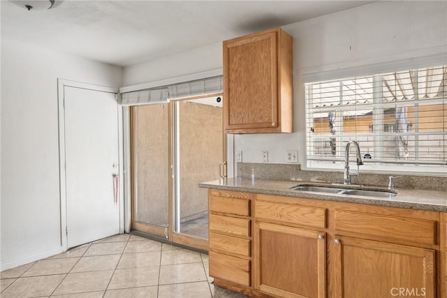 14735 Perham Dr, Moreno Valley, CA 92553 - kitchen with a sink, light tile patterned floors, and brown cabinetry