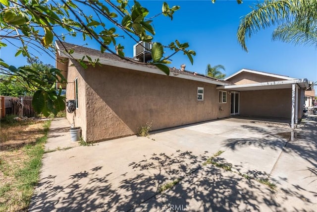 14735 Perham Dr, Moreno Valley, CA 92553 - rear view of house with stucco siding, fence, a patio area, and a carport