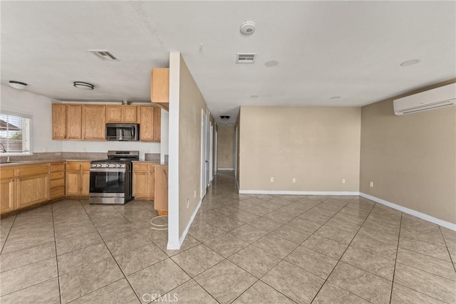 14735 Perham Dr, Moreno Valley, CA 92553 - kitchen featuring stainless steel appliances, a wall unit AC, light tile patterned floors, and baseboards