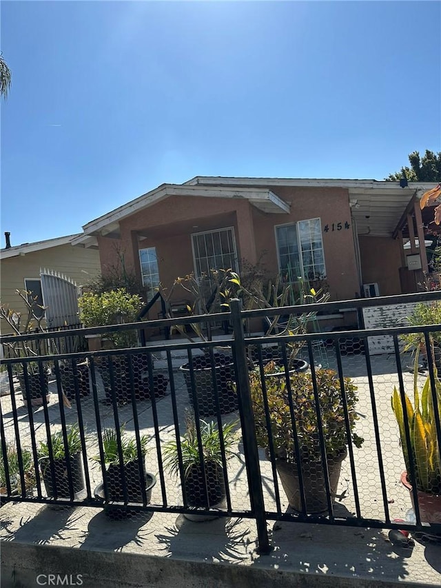 view of front of house featuring stucco siding and fence