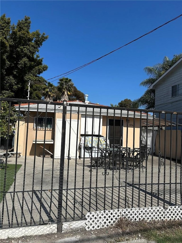 view of gate with fence and a patio area