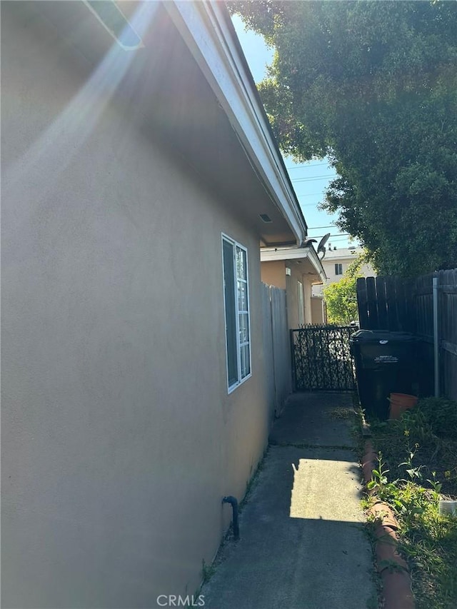 view of home's exterior with fence and stucco siding