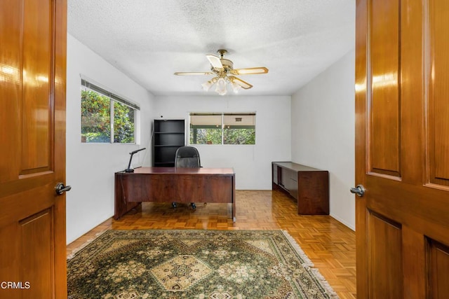 office space with a ceiling fan and a textured ceiling