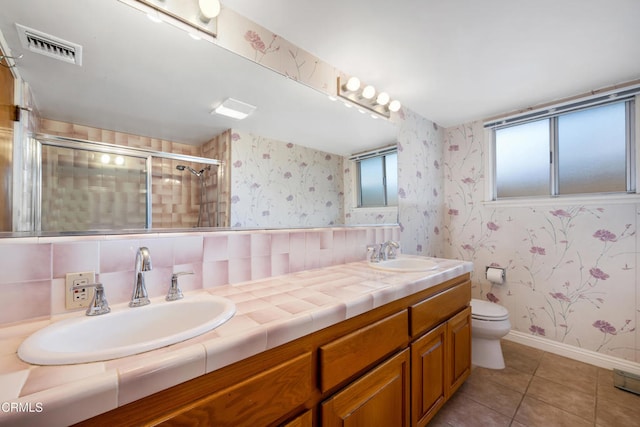 bathroom featuring a shower stall, wallpapered walls, visible vents, and a sink
