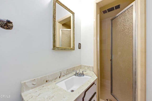 bathroom featuring a stall shower, vanity, and visible vents