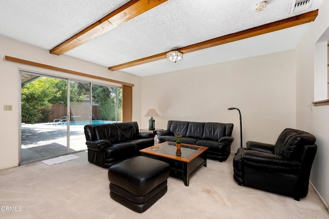 carpeted living room featuring a textured ceiling, visible vents, and beamed ceiling