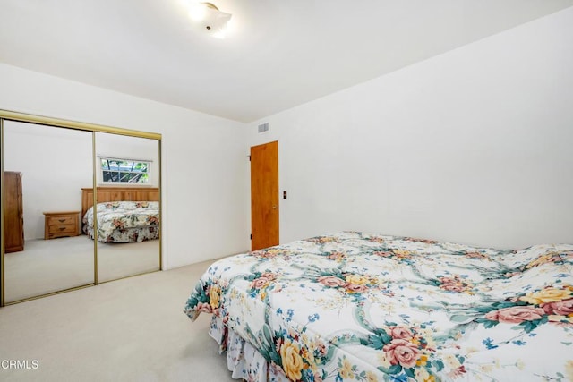 bedroom with a closet, visible vents, and carpet floors