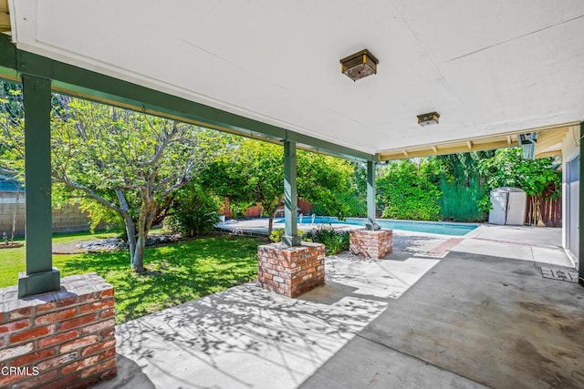 view of patio featuring an outdoor pool and fence