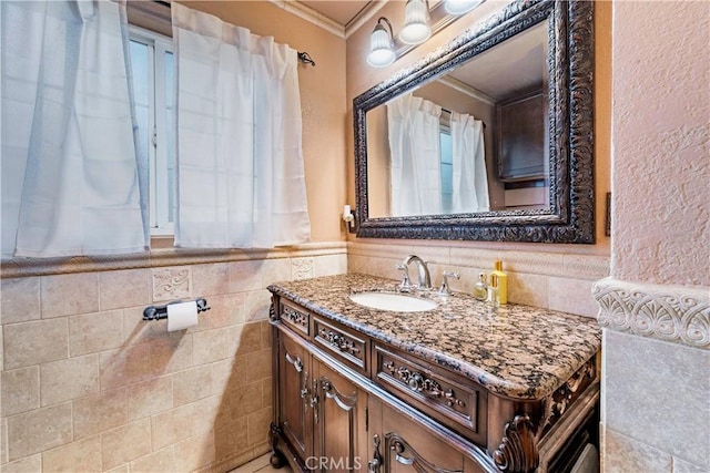 bathroom with crown molding, wainscoting, tile walls, and vanity