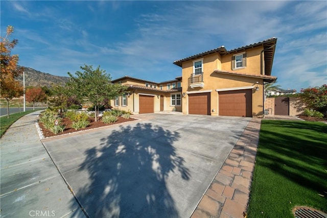 mediterranean / spanish home with concrete driveway, stucco siding, a garage, and a tile roof