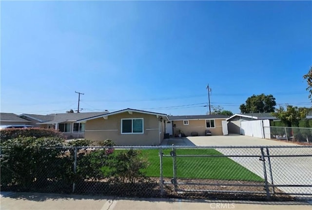 ranch-style home featuring a fenced front yard, stucco siding, driveway, and a front yard