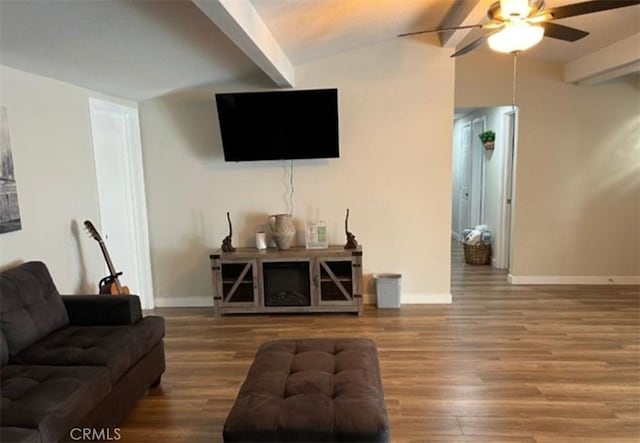 living area featuring wood finished floors, baseboards, ceiling fan, and vaulted ceiling with beams