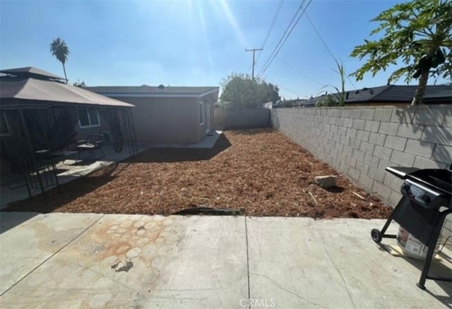 view of yard featuring a fenced backyard, a gazebo, and a patio