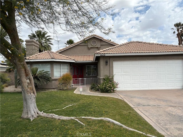 68430 Concepcion Rd, Cathedral City, CA 92234 - ranch-style house with driveway, a tiled roof, an attached garage, stucco siding, and a front yard