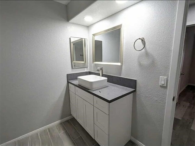 68430 Concepcion Rd, Cathedral City, CA 92234 - bathroom featuring vanity, wood tiled floor, baseboards, and a textured wall