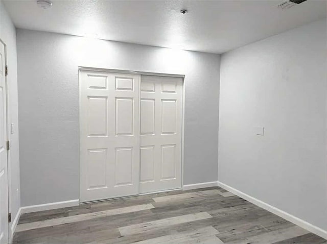68430 Concepcion Rd, Cathedral City, CA 92234 - unfurnished bedroom featuring a closet, baseboards, visible vents, and wood finished floors