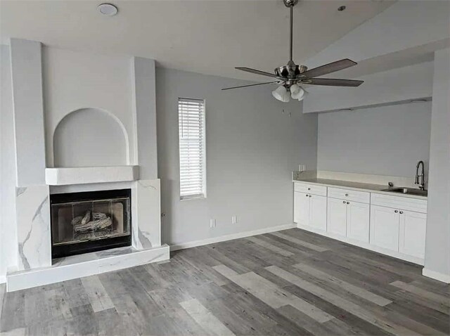 68430 Concepcion Rd, Cathedral City, CA 92234 - unfurnished living room featuring wood finished floors, a ceiling fan, a sink, a glass covered fireplace, and lofted ceiling