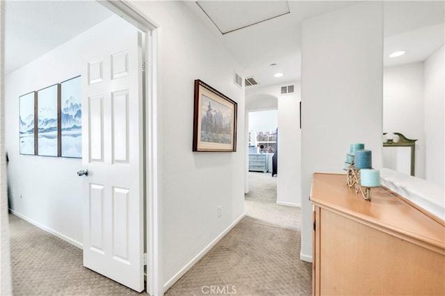 hallway with baseboards, light carpet, and visible vents