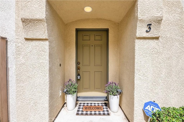 property entrance with stucco siding
