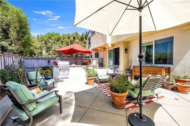 view of patio with area for grilling, outdoor lounge area, a grill, and a fenced backyard