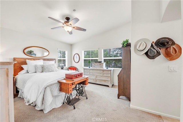 bedroom with light carpet, lofted ceiling, baseboards, and a ceiling fan
